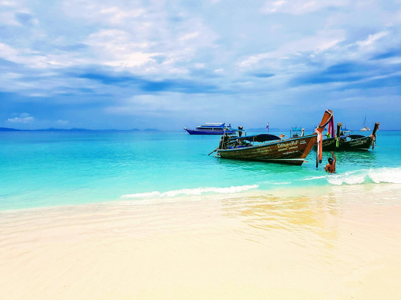 Longtail boats on a white sand beach