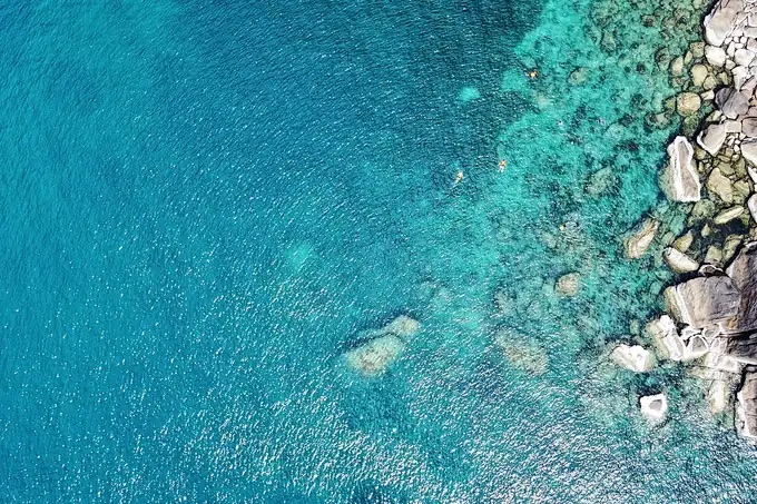 Clear turquoise water and rocks seen from above